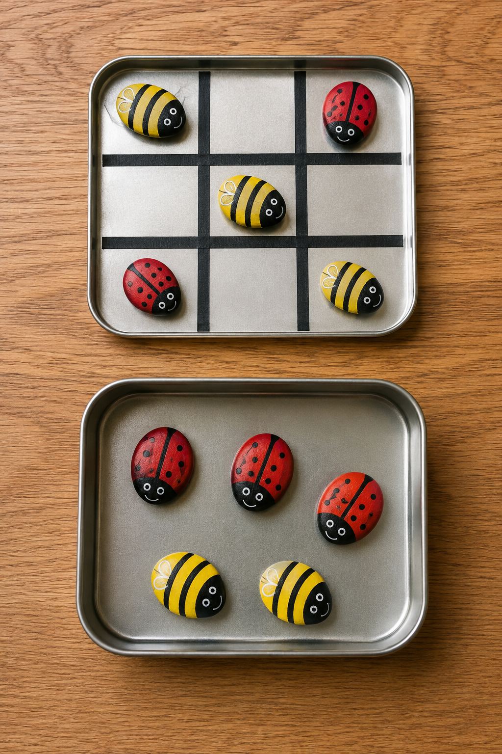 Flat metal tin decorated with a grid tape line holding painted ladybug and bumblebee river stone game markers