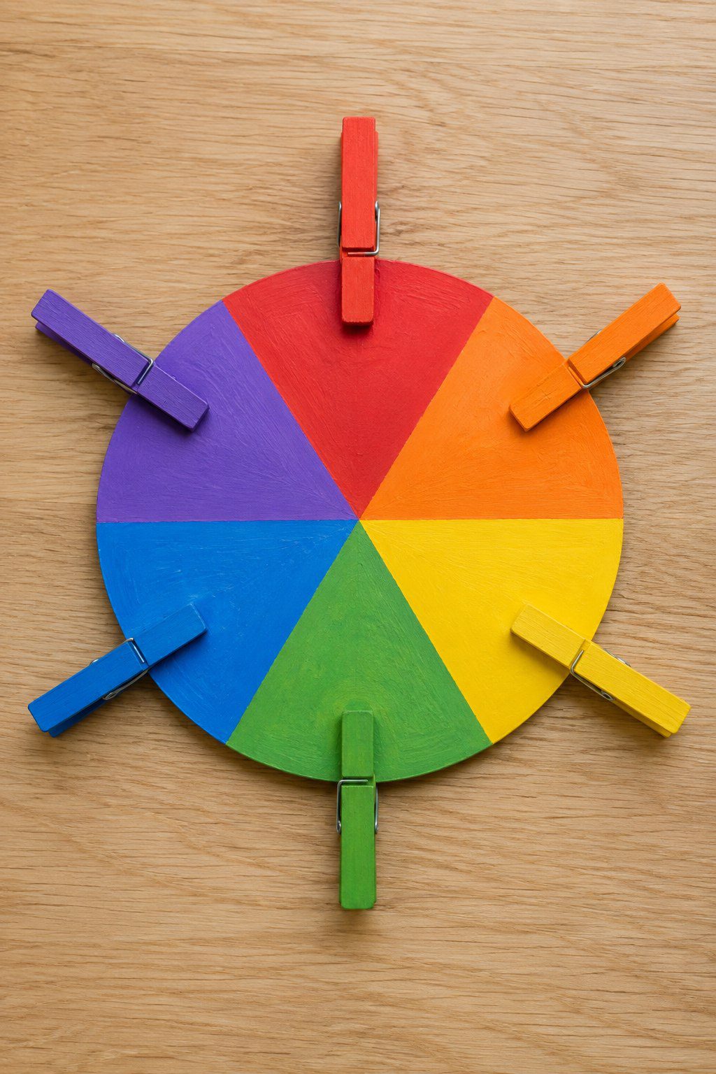 Heavy cardstock wheel divided into colorful slices paired with painted wooden clothespins clipped to matching color sections